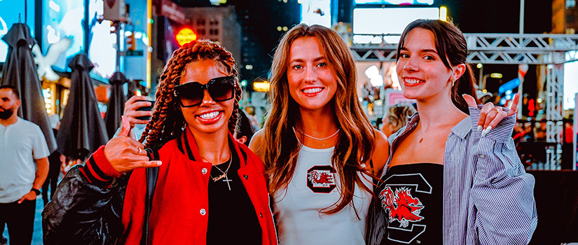2022年9月，三名零售专业的学生在纽约时装周的时代广场合影留念。