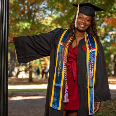 BAIS毕业生西妮西亚·韦弗在南加州大学校园里戴着帽子和长袍拍照。