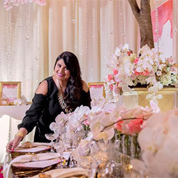 Nirjary Desai站在一间被装饰成新娘招待会的房间里，里面有茂盛的鲜花和正式的餐桌摆设