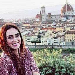 克里斯蒂·马丁(Kristy Martin)坐在一座山脊上，俯瞰意大利佛罗伦萨的圣玛丽亚·德尔·菲奥里大教堂。