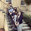 HRSM全球社区俱乐部的成员蒙面站在麦卡琴之家的台阶上