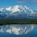 阿拉斯加被白雪覆盖的山脉，前景是一个湖泊。