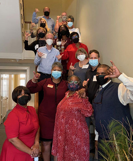戴着面具的HRSM教师和工作人员聚集在麦卡琴楼内的楼梯上，为多元化、公平和包容证书课程的参与者举行午餐