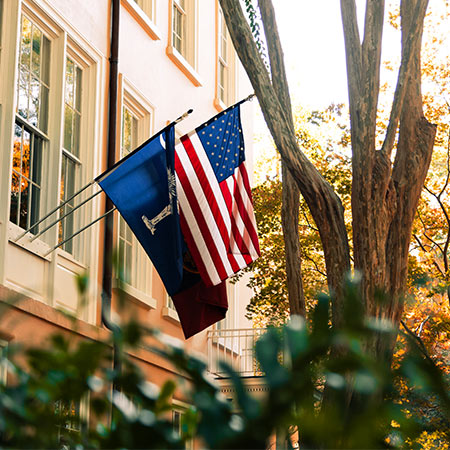 美国国旗和SC州国旗飘扬在历史性的马蹄铁上的总统官邸前。