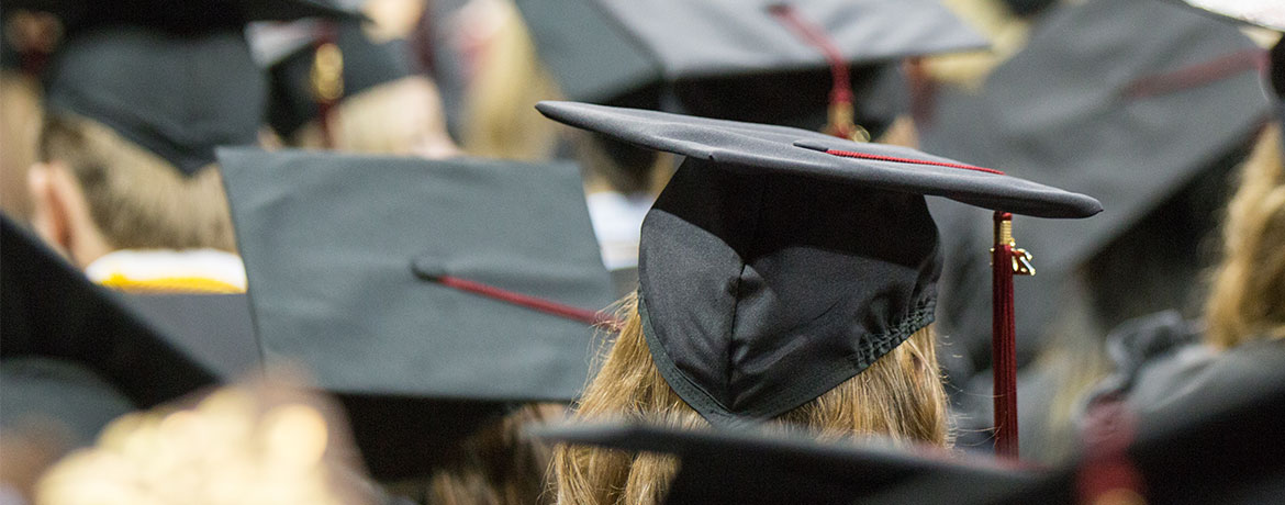 一群学生从后面戴着毕业帽。