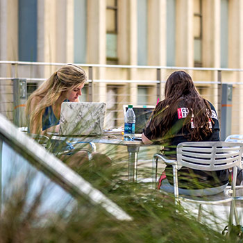 学生们一起在户外的桌子上学习。