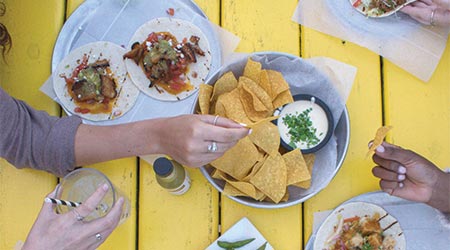 一桌墨西哥食物的视图，包括薯片、queso和tacos。