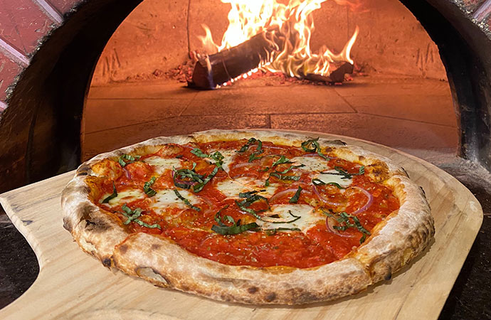 在Il Focolare披萨店，一个刚从柴火烤箱里出来的披萨。