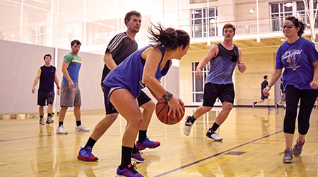 男女同校在健康中心的球场上打篮球。