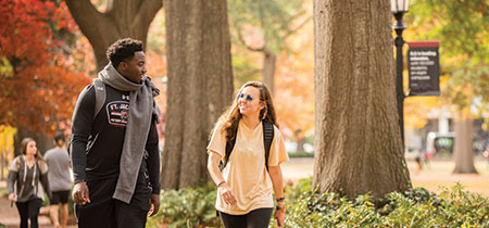 在一个美丽的秋日，两个学生走在历史悠久的马蹄形小路上。