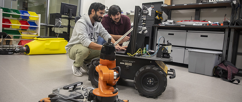 两个学生计划一个机器人在实验室