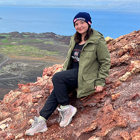 Ashlyn Ooi坐在冰岛的岩石上。
