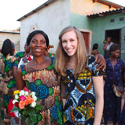 在赞比亚的一个村庄，“穿上希望”项目的创始人艾米·巴迪与她的一名学生和其他几位穿着鲜艳的女性站在一起，参加“穿上希望”项目的毕业典礼。