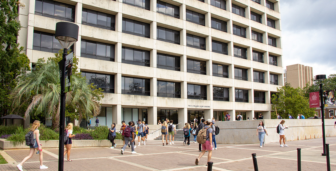 在2022年秋季课程的第一天，学生们在Close-Hipp大楼的主入口外面散步。