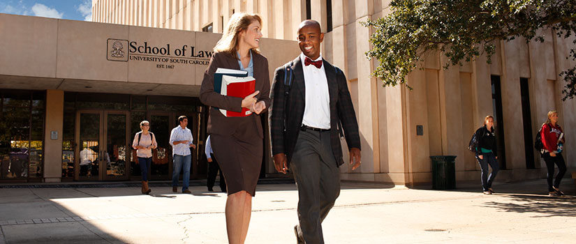 一名白人女学生和一名黑人男学生在走出南卡罗来纳法学院以前的建筑时交谈。