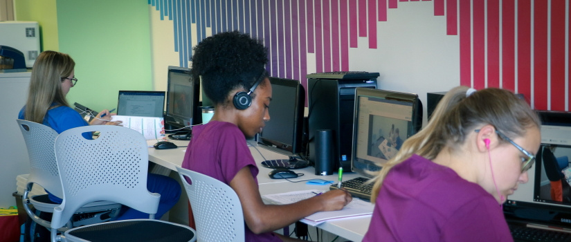 学生们坐在电脑前进行远程语音和听力评估