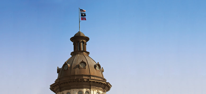 州议会大厦顶部的圆顶上悬挂着美国国旗、南卡州国旗和南卡州旗帜