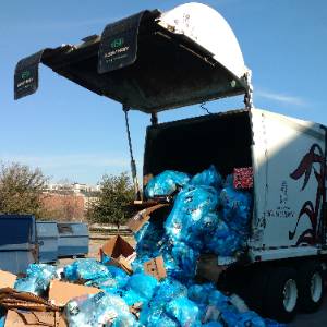 一辆装满蓝色垃圾袋的大垃圾车