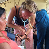 阿莱娜·斯特基(Alaina Sturkie)在蒂米全球健康诊所为一名当地妇女测量血压。