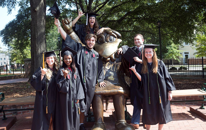 UofSC毕业生与自大雕像合影。