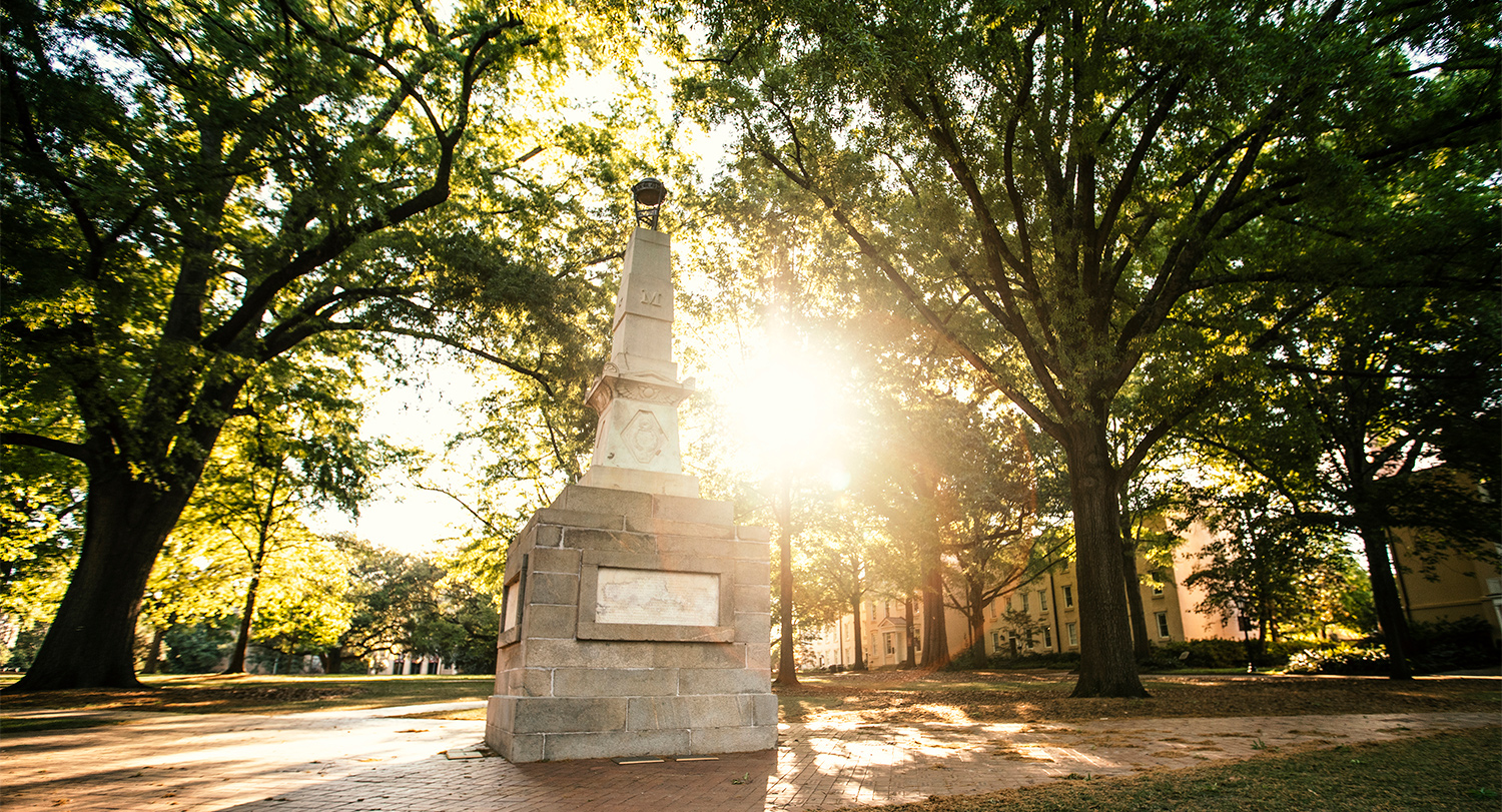 阳光透过马蹄形历史马蹄形上马克斯西纪念碑后面的树木。