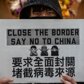 抗议者举着标语呼吁关闭边境