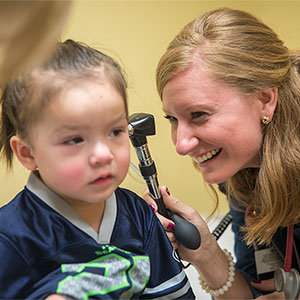 一个医科学生正在观察一个孩子的耳朵。