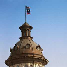 南卡罗莱纳州议会大楼的圆顶上飘扬着三面国旗，分别是美国、该州和一面gameccock国旗