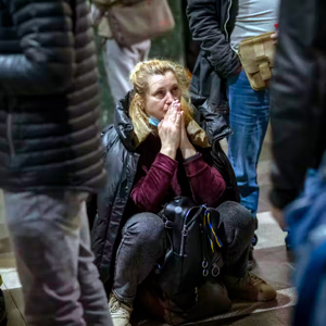 乌克兰一名女子在等待离开基辅的火车时似乎在祈祷